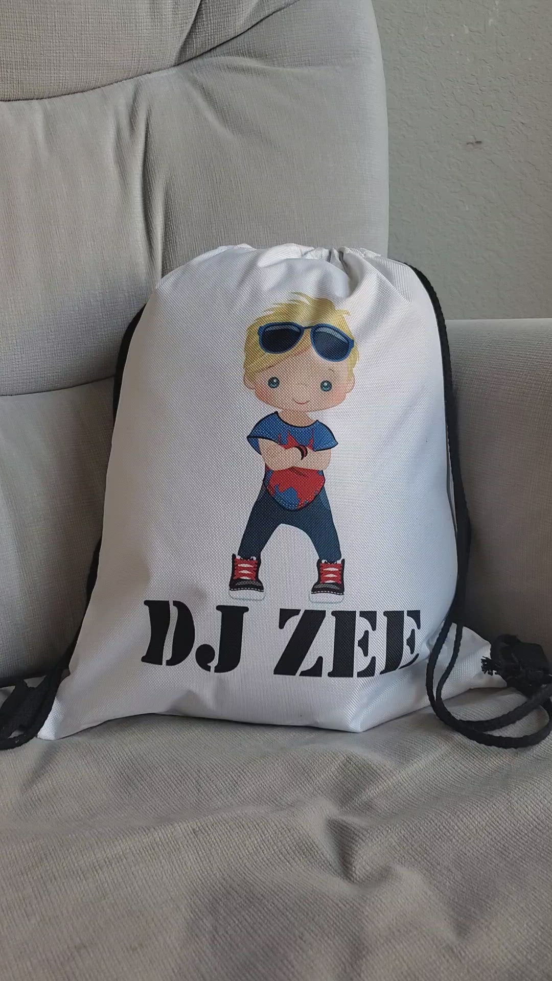 This is a white drawstring backpack customizable with the child's name and a boy in hip hop clothing. This makes a great unique gift for dance recitals for boys.