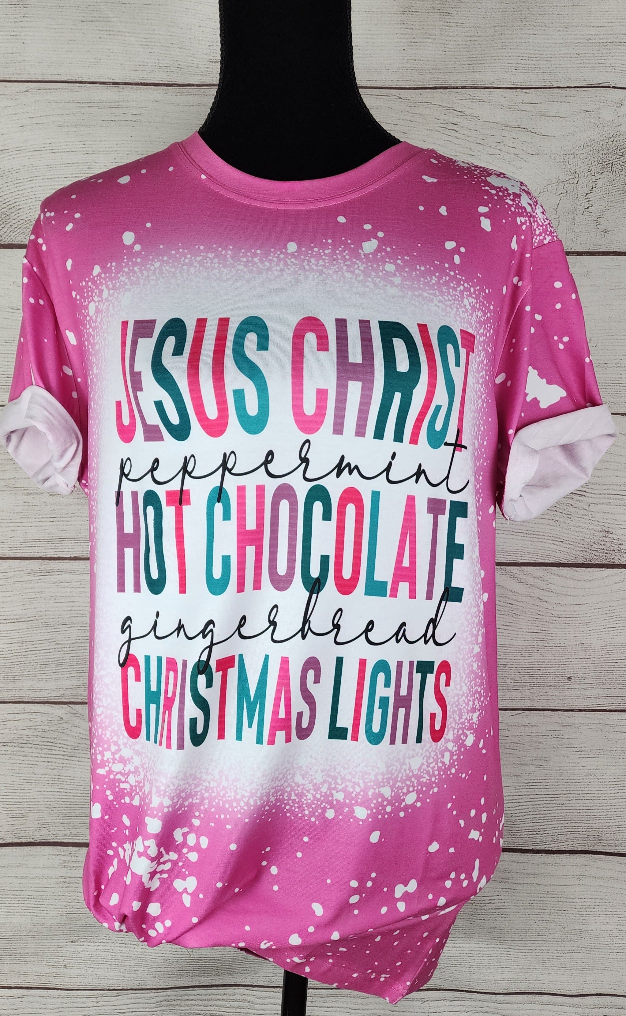 A shirt that says "Jesus Christ, Peppermint, Hot Chocolate, Gingerbread, Christmas  Lights