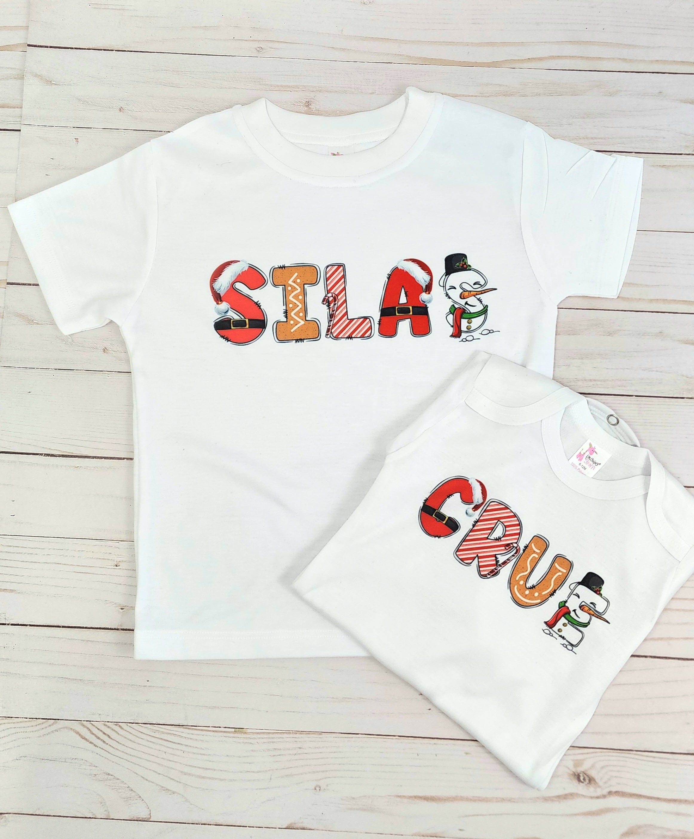 2 shirts with the name Silca and Crue . Each letter has a different character for example Santa S , Gingerbread I , Candy Cane L, Santa A, Snowman S  and it spells SILAS